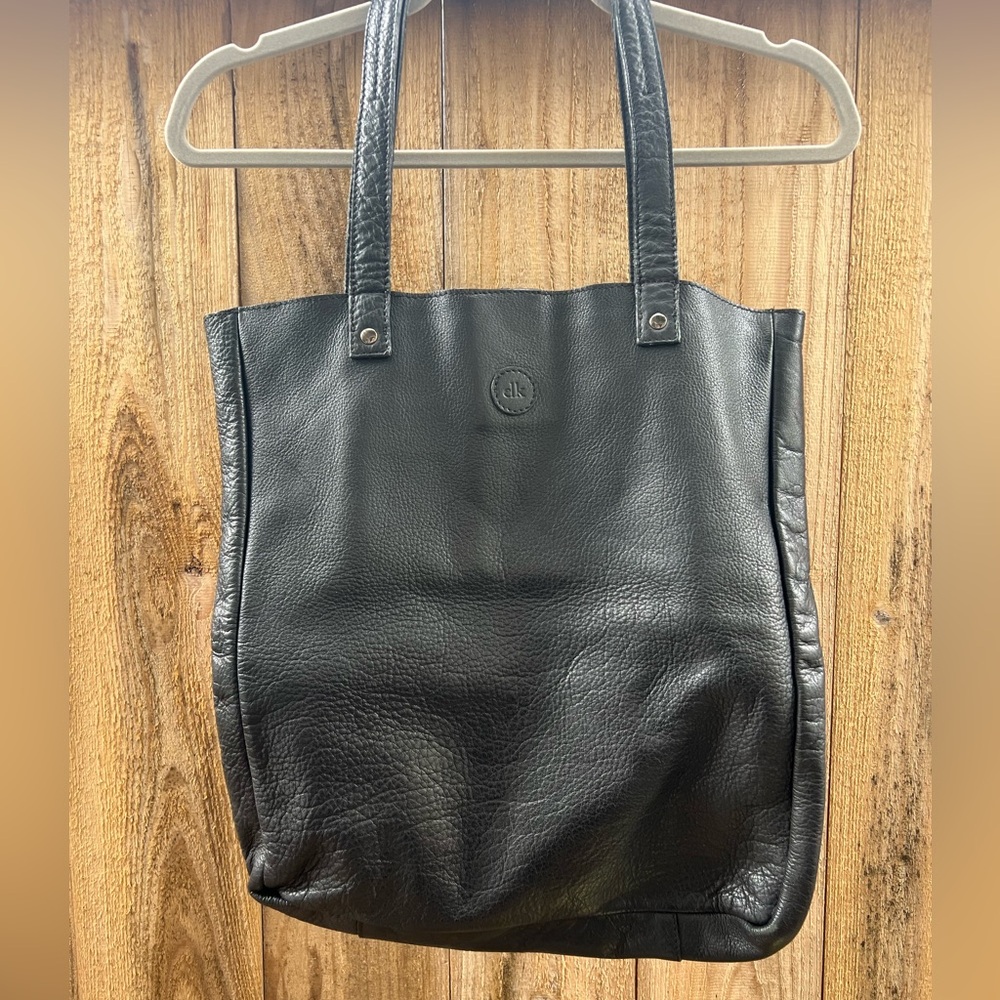 Black leather tote bag with snap closure.